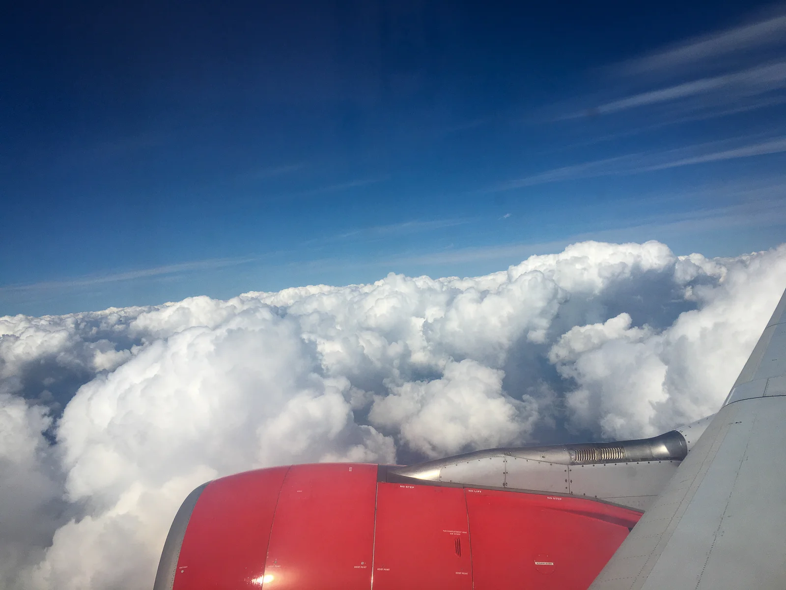 Blick aus dem Flugzeugfenster auf den Triebwerk und die Wolkendecke über dem Atlantik auf dem Weg nach New York