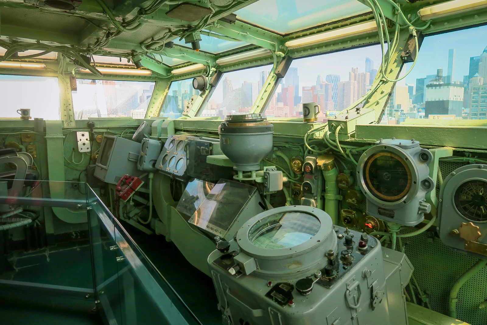 BrĂĽcke der USS Intrepid mit Navigationssystem Steuerstand und Blick auf Manhattan Skyline durch die Fenster